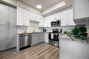 a kitchen with stainless steel appliances and white cabinets