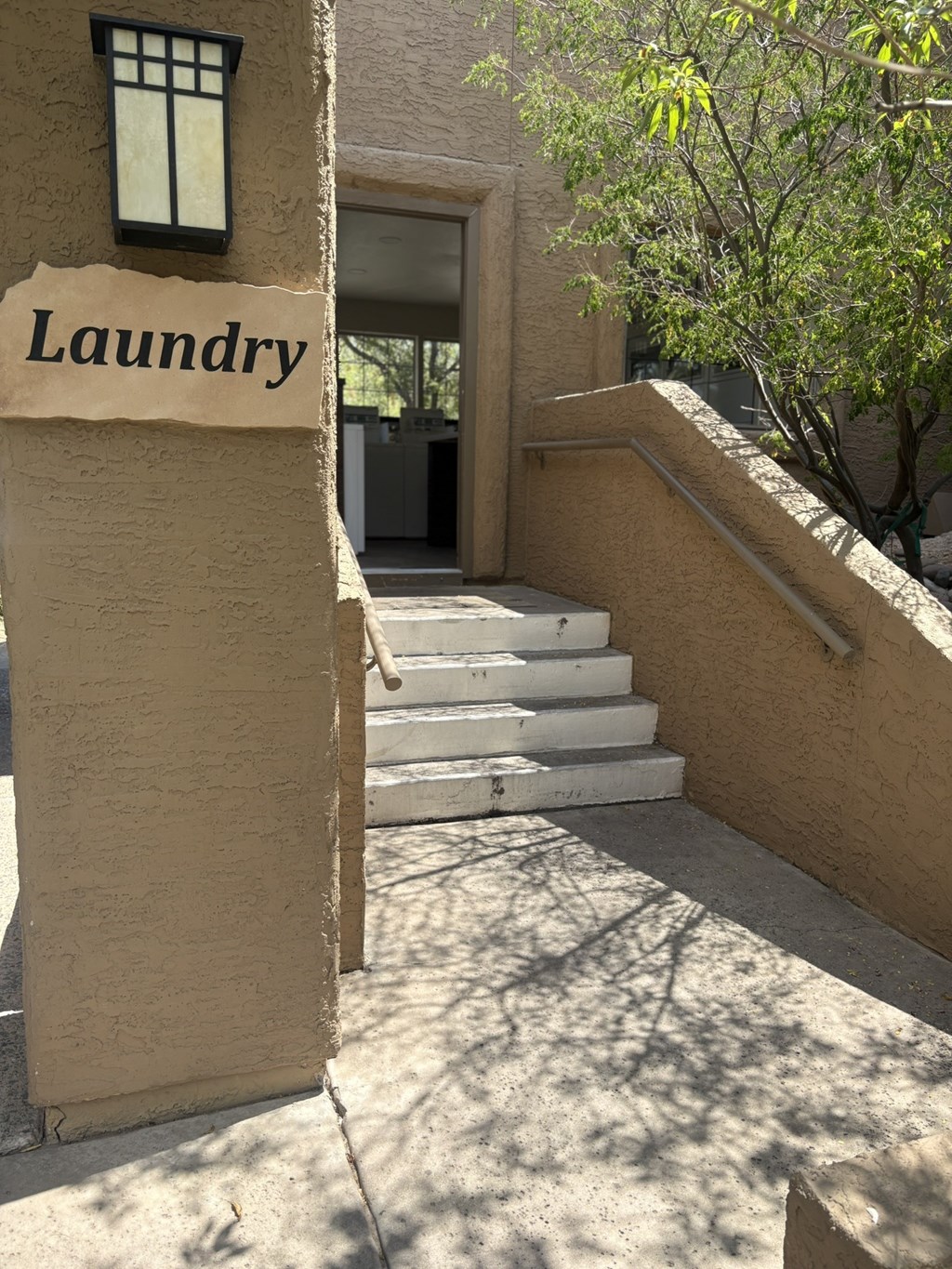Laundry sign on a wall next to a staircase.
