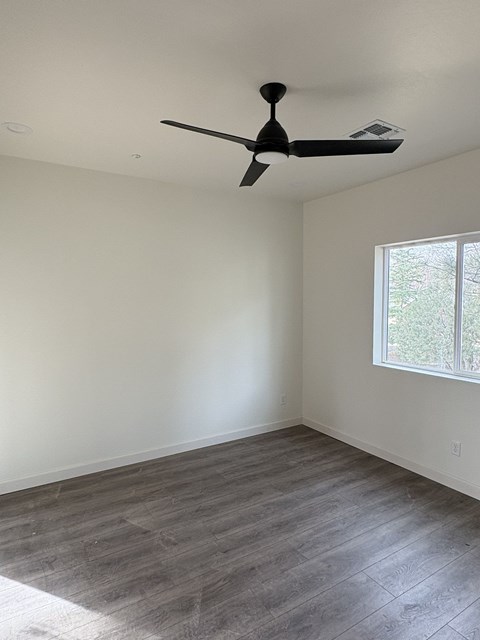 A room with a ceiling fan and a window.