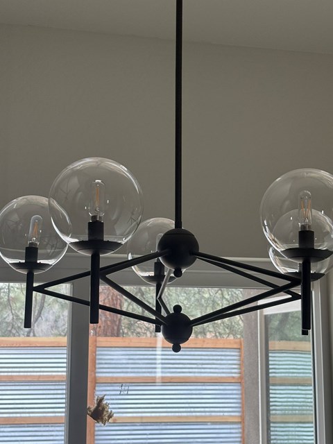 A chandelier with four lights hanging from the ceiling.