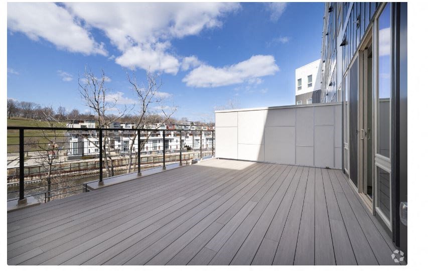 a balcony with a view of a city and a blue sky
