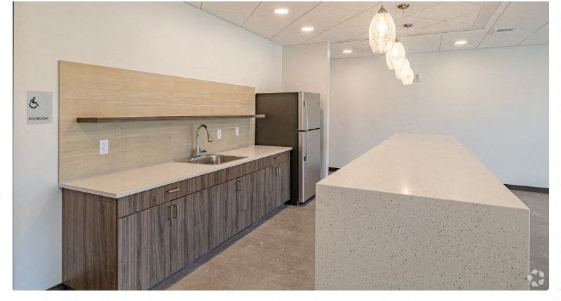 an empty kitchen with a sink and a refrigerator