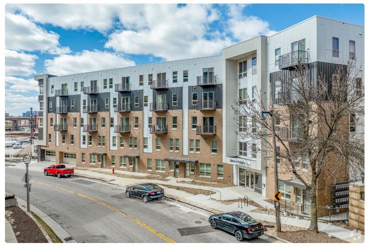 a large apartment building with cars parked in front of it