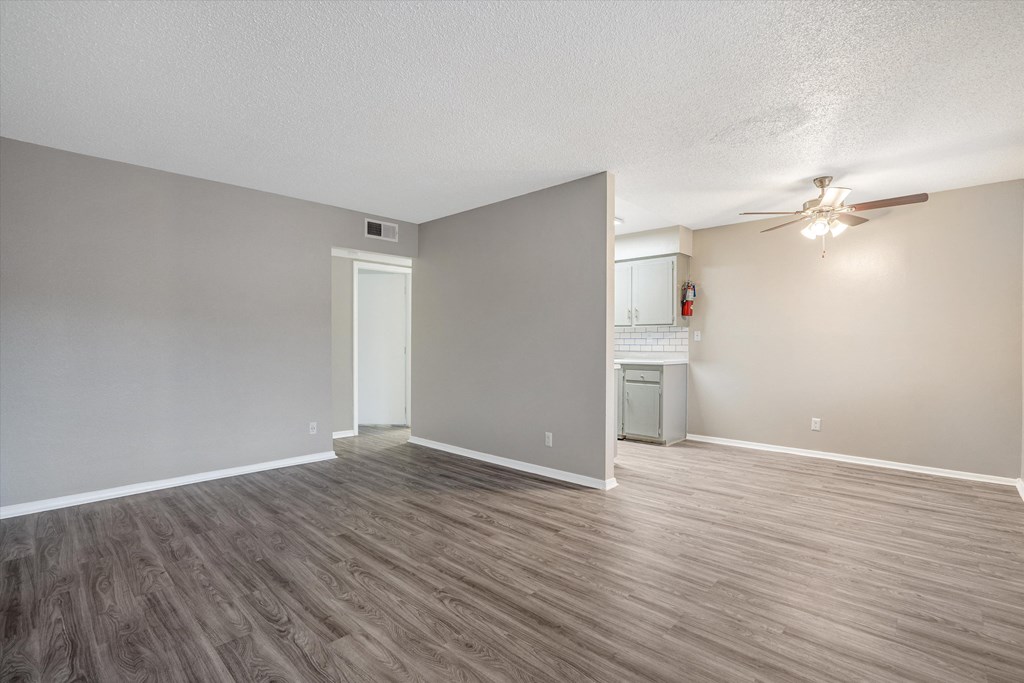 the living room and kitchen of an empty apartment