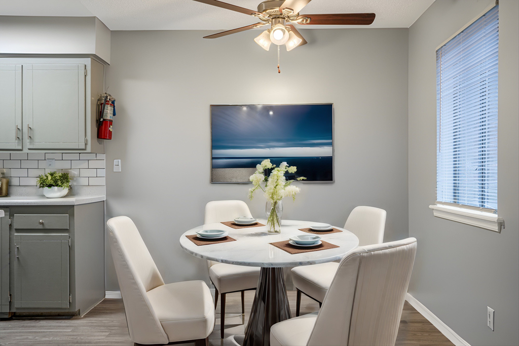 a dining room with a table and chairs and a ceiling fan