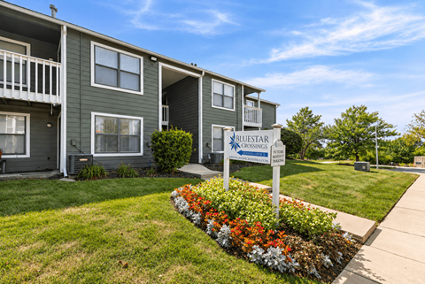 A sign for Bluestar Crossing in front of a building.