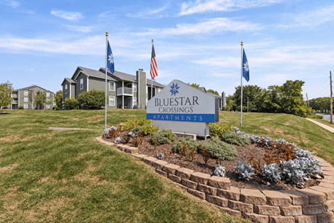 The sign in front of the building says Bluestar Crossings Apartments.