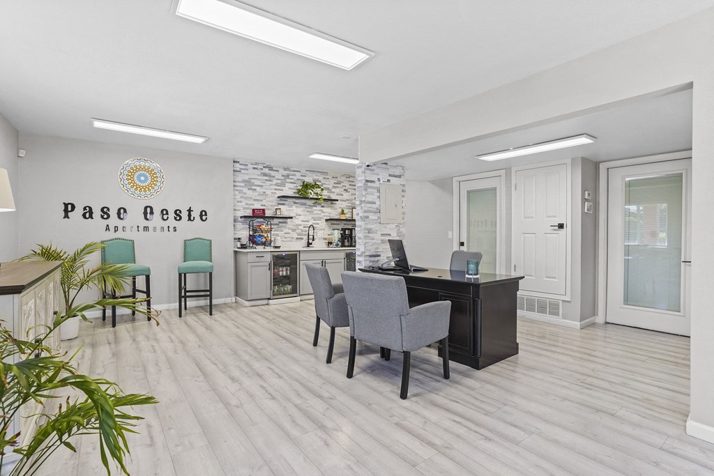 an office with a desk and chairs in front of a counter with a computer