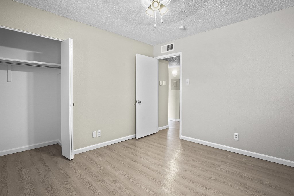 an empty living room with wood flooring and white walls