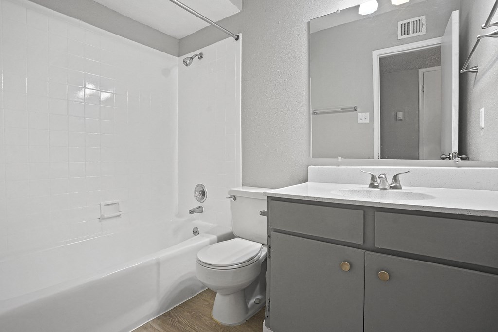 a bathroom with a toilet sink and tub and a mirror