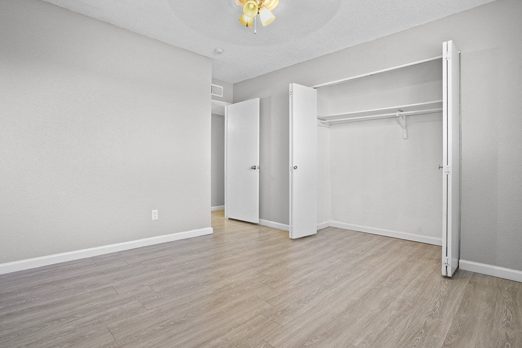 the living room and bedroom of an empty apartment with white walls and wood floors