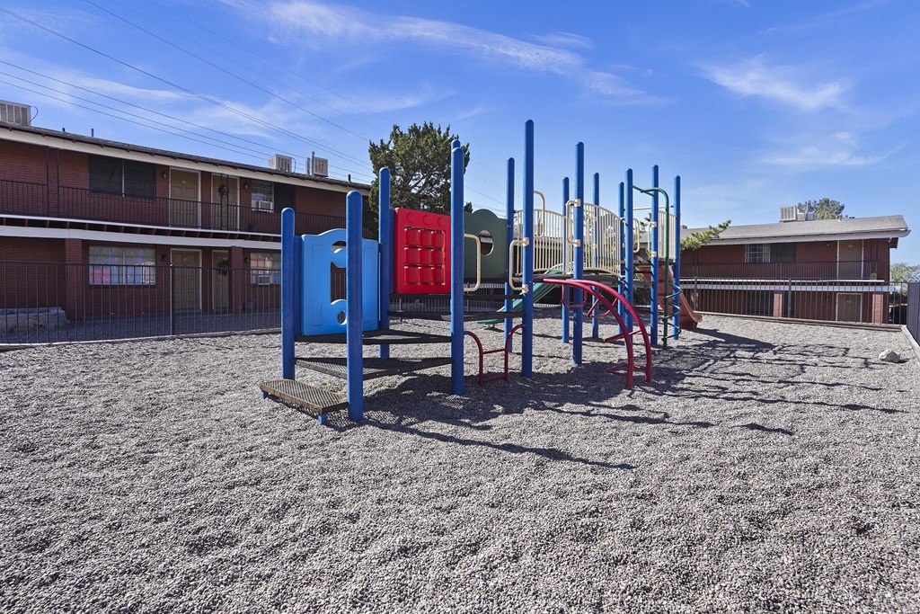 an empty playground at a school with a building in the background