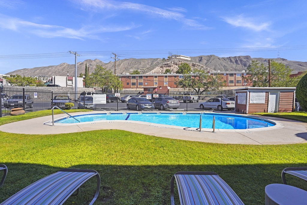 a pool with mountains in the background at an apartment complex