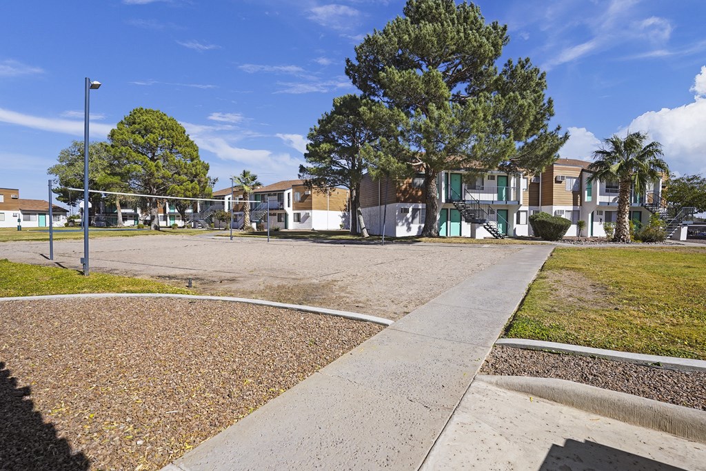 a park with a volleyball court in front of some houses