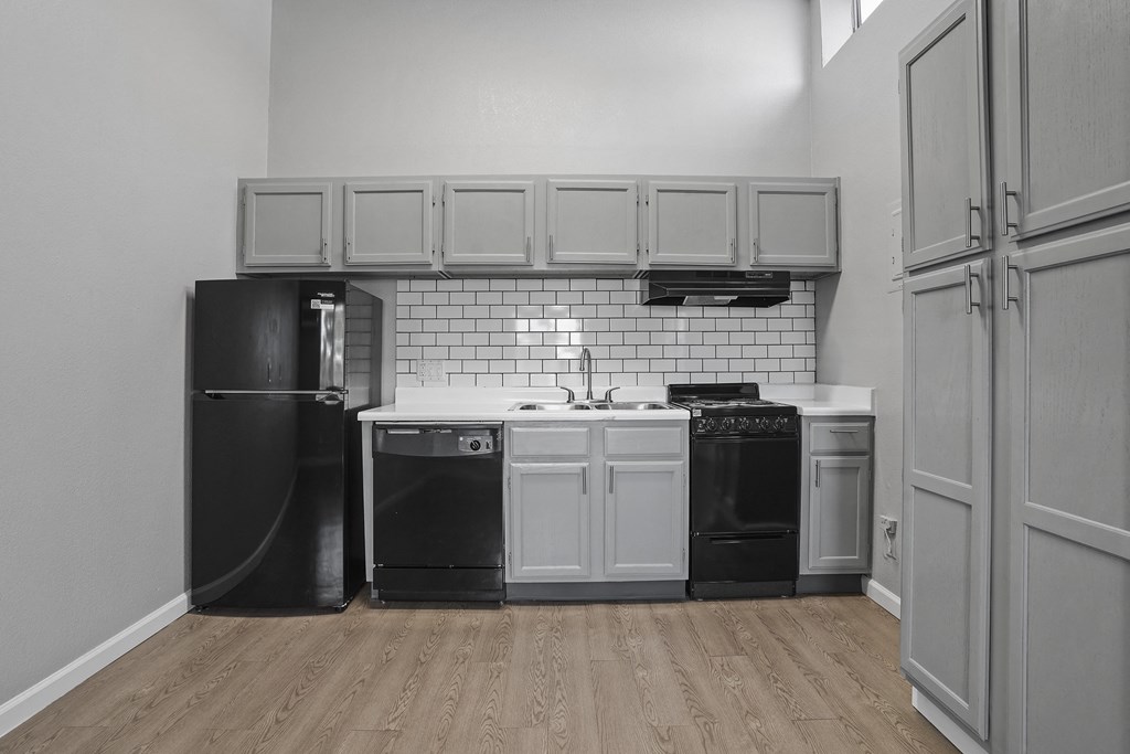 a kitchen with white cabinets and black appliances and a black refrigerator