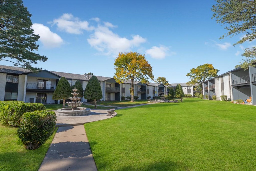 a courtyard with a fountain in front of an apartment building
