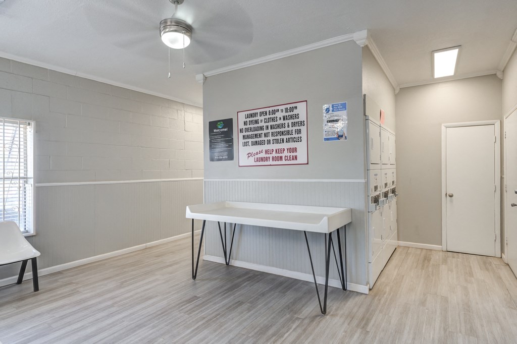 a room with a white table in front of a wall and a door