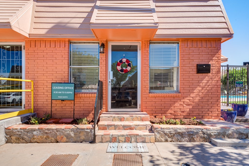 the front of a brick building with a wreath on the door