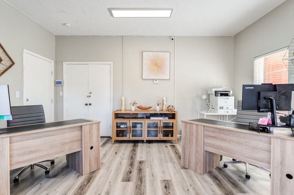 two desks and a computer in a room with wood floors