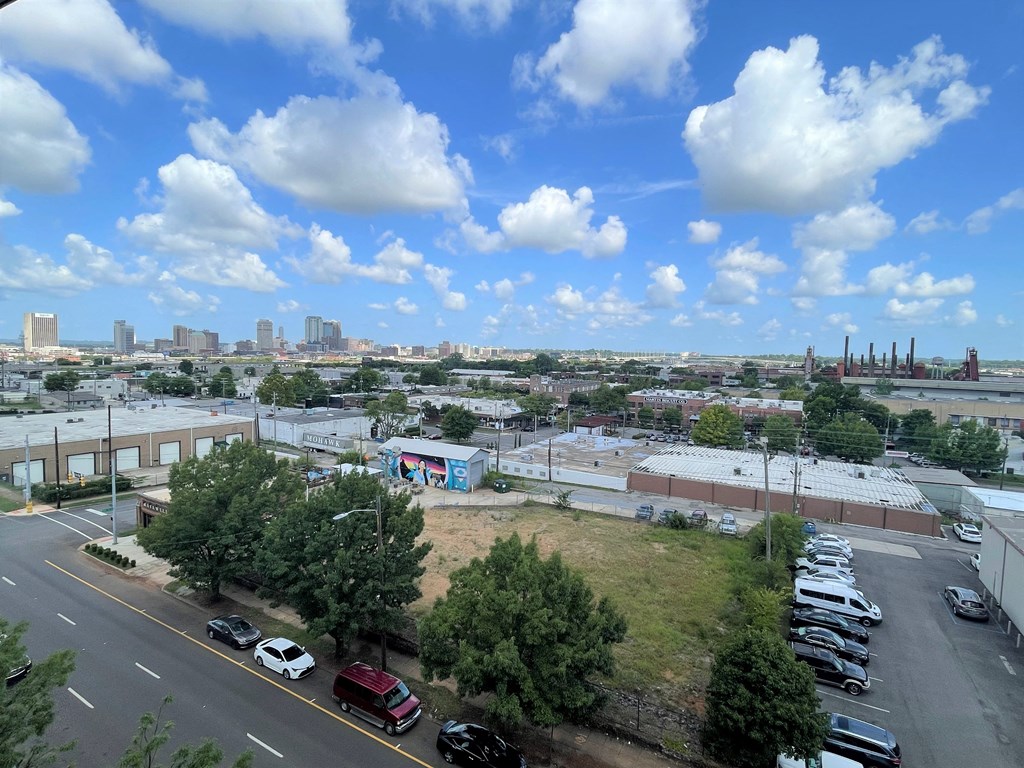 an aerial view of a parking lot with a city in the background