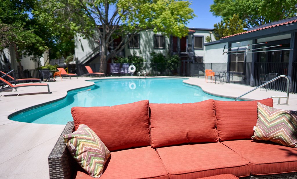 a pool with a couch in front of a swimming pool