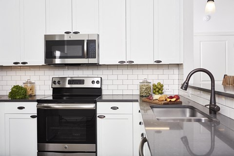 a kitchen with white cabinets and a stove and a sink