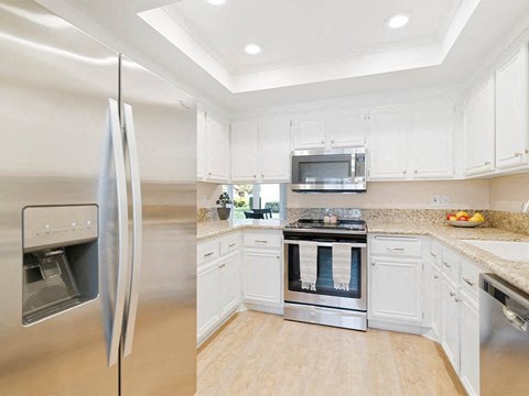 A modern kitchen with a stainless steel refrigerator and oven.