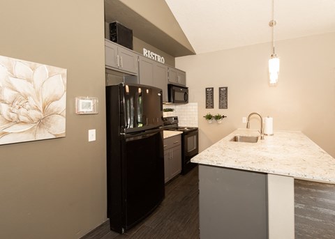 a kitchen with stainless steel appliances and a marble counter top