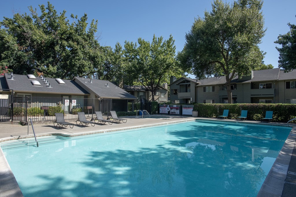 swimming pool with lounge chairs at Delta Pointe Apartments, Sacramento, CA