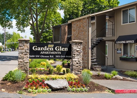 A sign for Garden Glen Apartments is in front of a building.