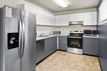 A kitchen with a stainless steel refrigerator and a stainless steel oven.