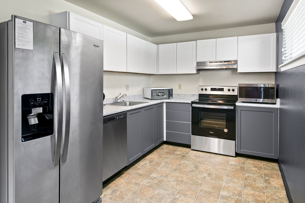 A kitchen with a stainless steel refrigerator and a stainless steel oven.