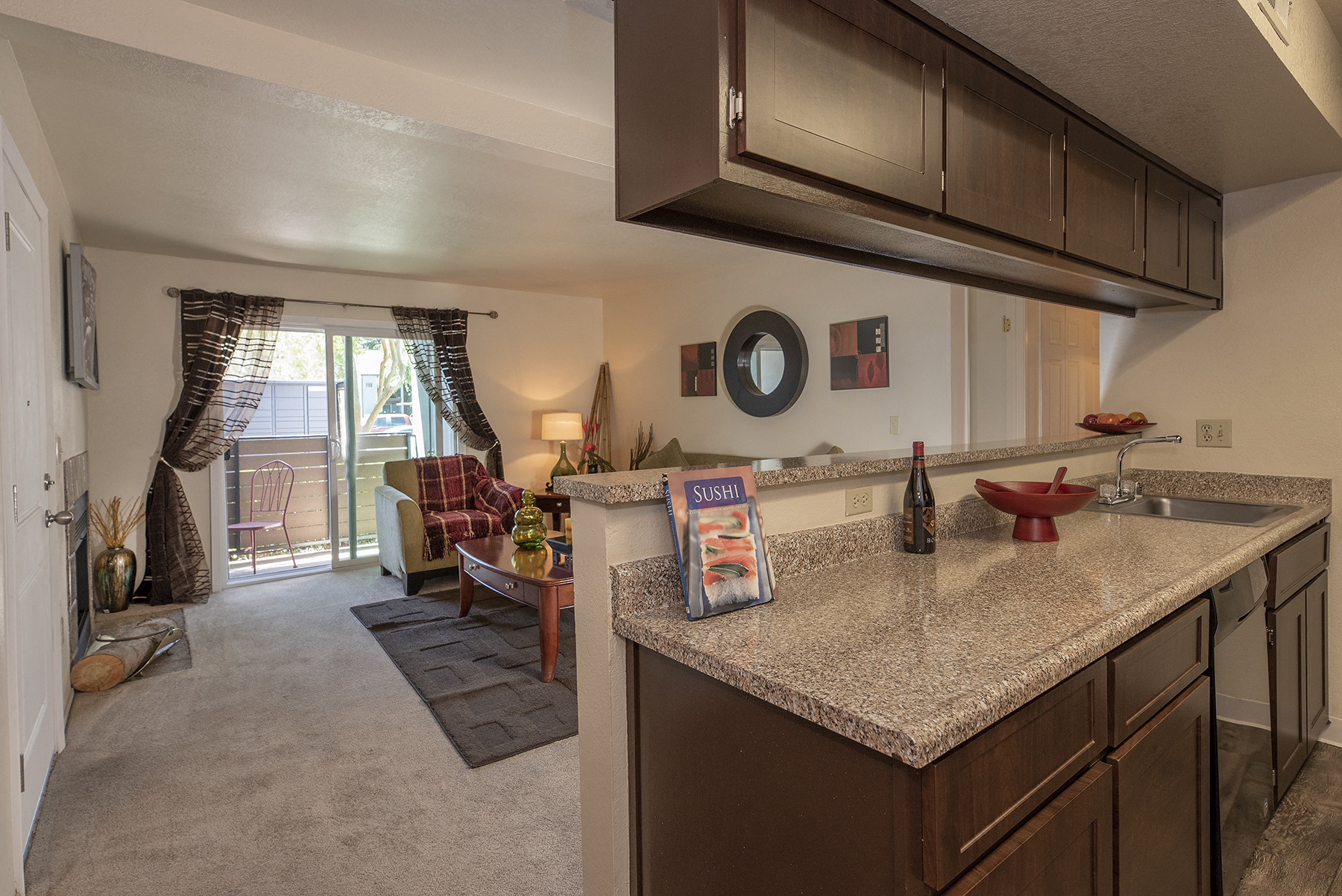a kitchen with a counter top and a living room with a couch