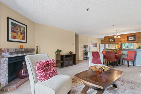 a living room with a fireplace and a table with chairs