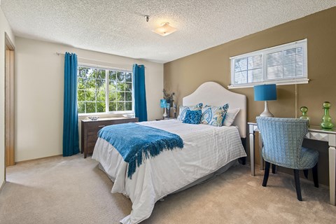 Model primary bedroom and furniture at Riverwood Apartments, Kent, Washington 98032