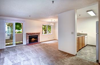 Living Room & Dining Room with cozy carpeting and a fireplace at Riverwood Apartments, Washington