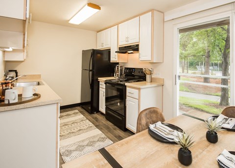 a kitchen and dining room with a black stove and refrigerator