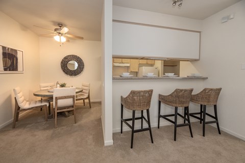 a living room and dining room with a table and chairs and a kitchen