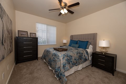 a bedroom with a bed and a ceiling fan