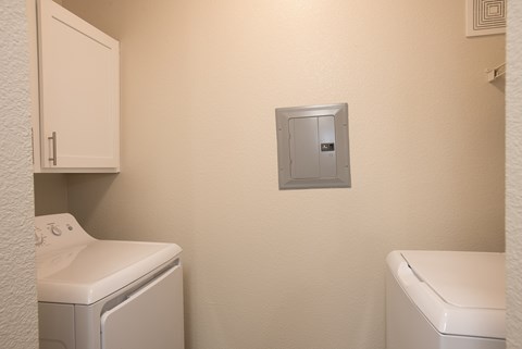 A laundry room with a washer and dryer and a safe.