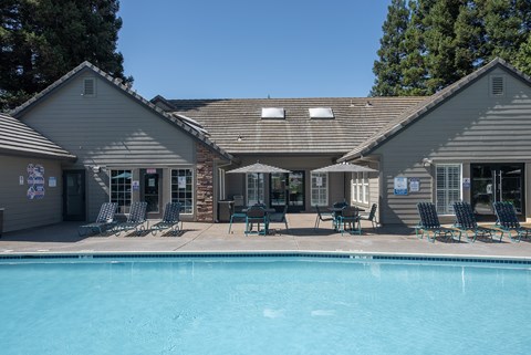 A swimming pool is surrounded by chairs and umbrellas outside at Sunset Summit, Rocklin, CA, 95765