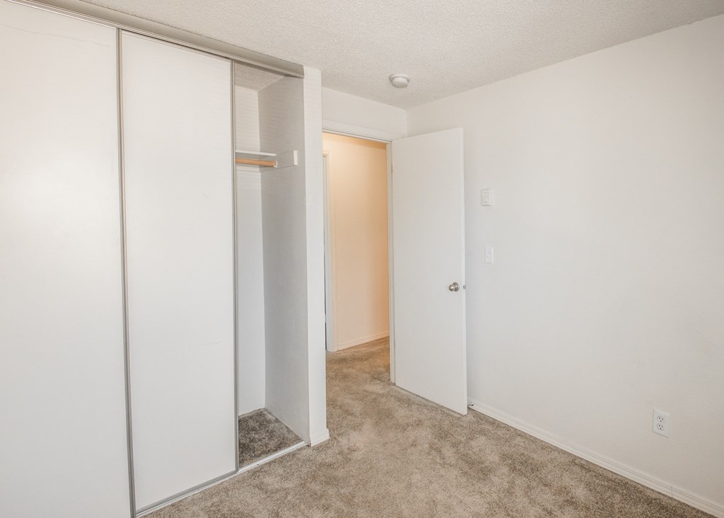 apartment bedroom with a white closet door and a carpeted floor at Todd Village Apartments, Oregon, 97062