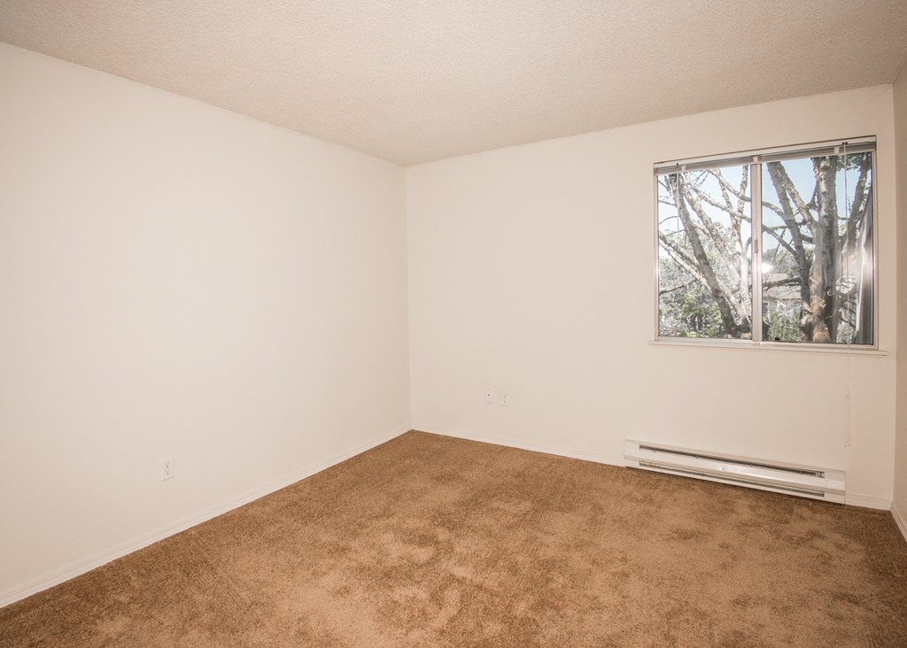 large bedroom with a  window and a carpeted floor at Todd Village Apartments, OR 97062