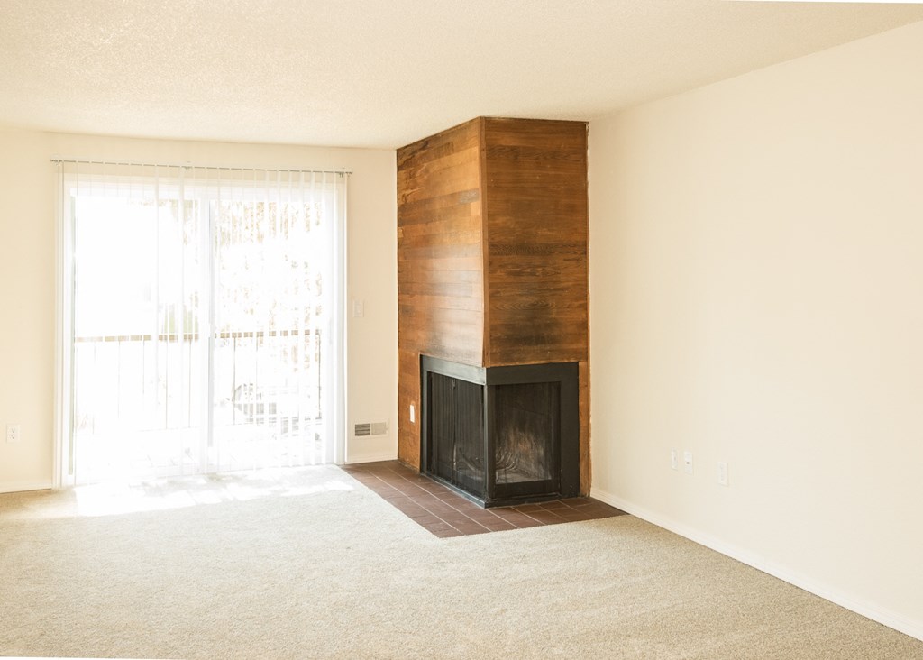 vacant apartment living room with a wood burning fireplace and a sliding glass door at Todd Village Apartments, Tualatin, OR