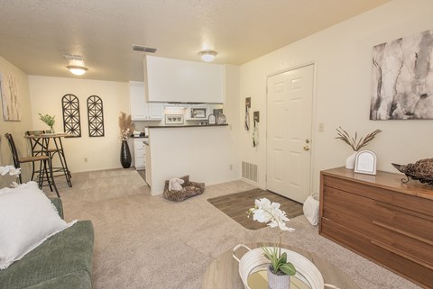 A living room with a green couch and a white wall.