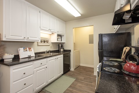 A kitchen with white cabinets and a black stove top.