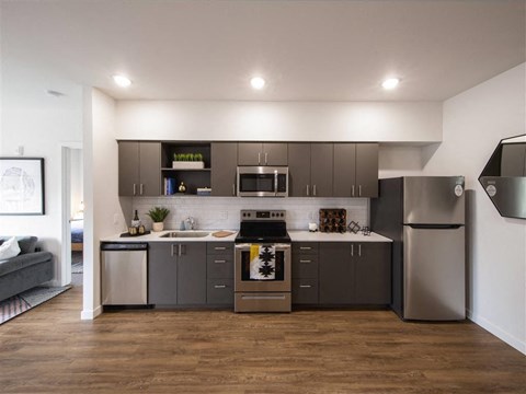 a kitchen with stainless steel appliances and gray cabinets
