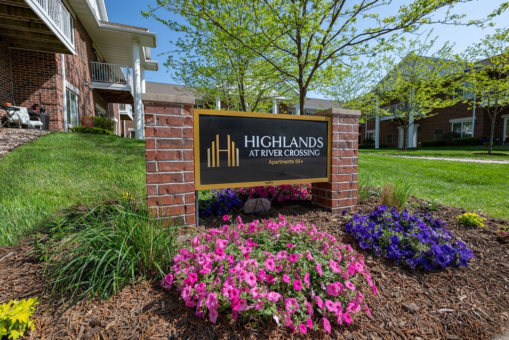 A sign for Highlands at River Crossing is in front of a building.