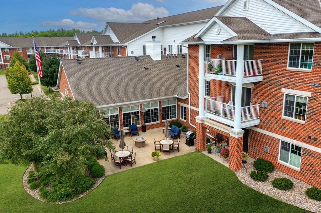 an aerial view of a large brick building with a balcony and a patio with a table and