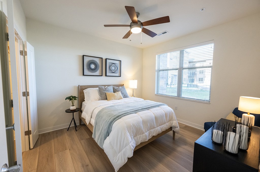 a bedroom with a ceiling fan and a bed